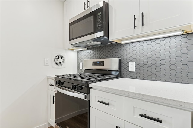 kitchen featuring decorative backsplash, appliances with stainless steel finishes, light stone countertops, wood-type flooring, and white cabinets