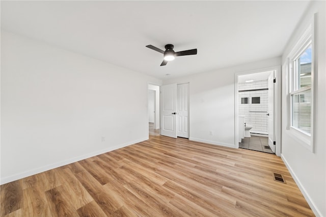 unfurnished bedroom with connected bathroom, light hardwood / wood-style flooring, and ceiling fan