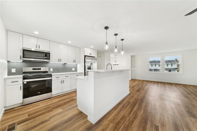 kitchen with white cabinetry, pendant lighting, dark hardwood / wood-style floors, and appliances with stainless steel finishes