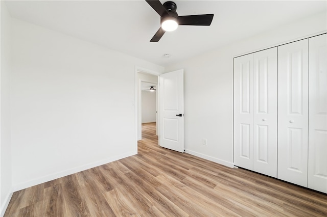 unfurnished bedroom with ceiling fan, light hardwood / wood-style floors, and a closet