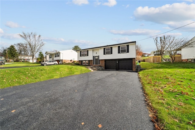 raised ranch with a front lawn and a garage