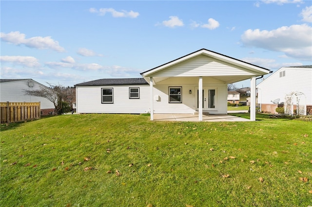 rear view of property featuring a lawn and a patio