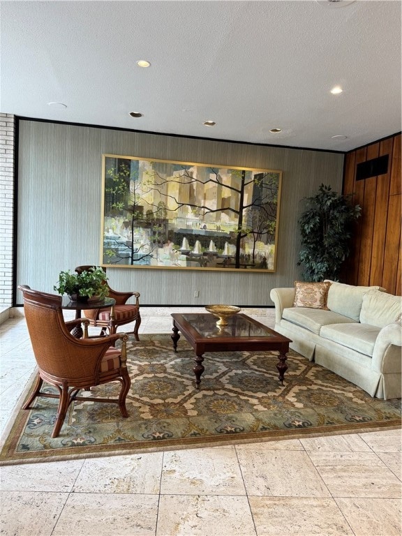 living room with a textured ceiling and wooden walls