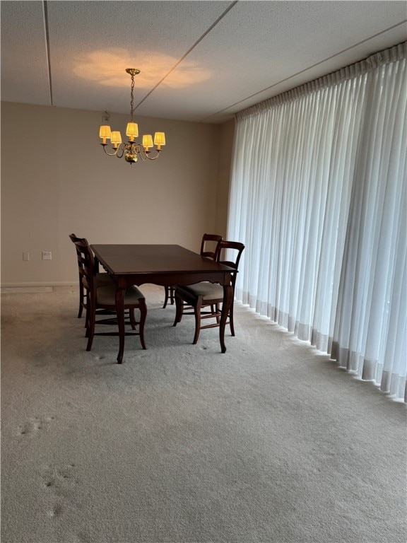 dining space featuring carpet, a notable chandelier, and a textured ceiling