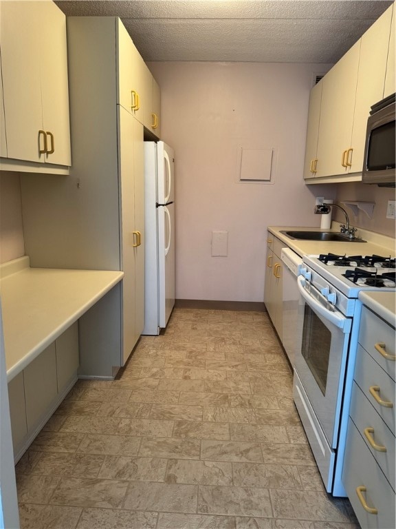 kitchen with white cabinets, white appliances, and sink