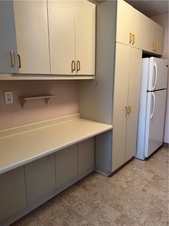 kitchen with a textured ceiling and white refrigerator