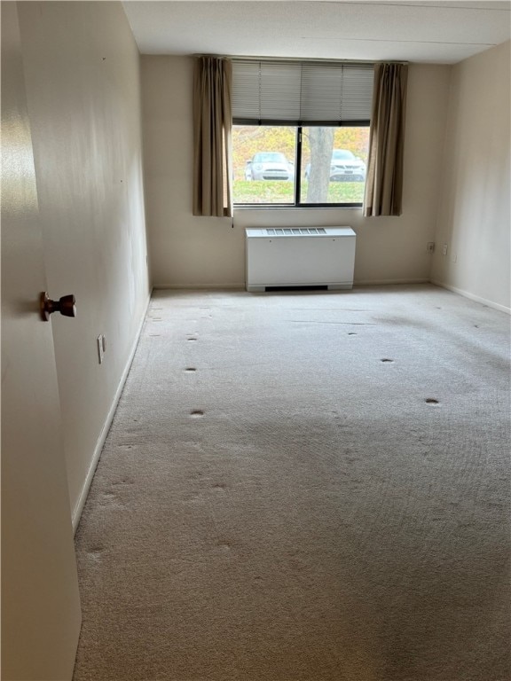 carpeted spare room with radiator heating unit