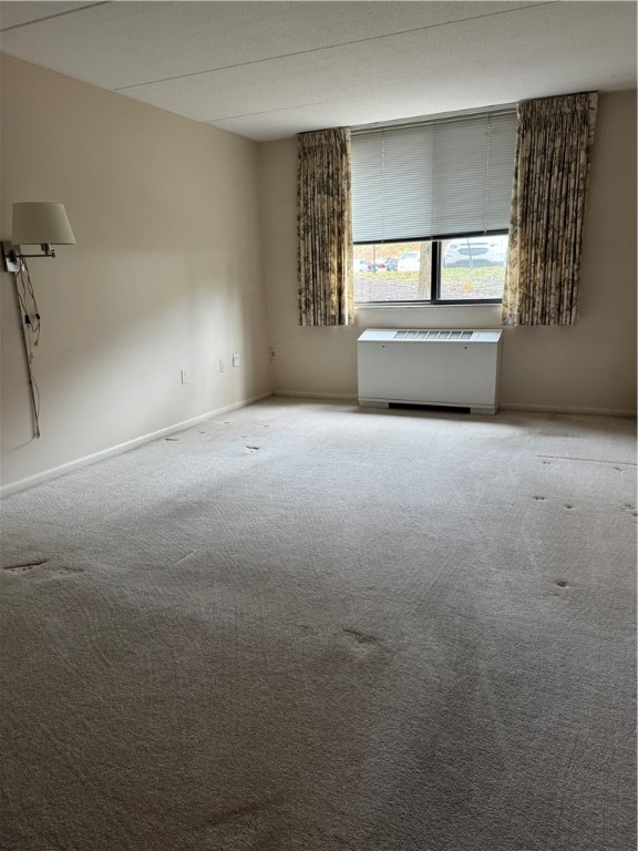 carpeted empty room with radiator