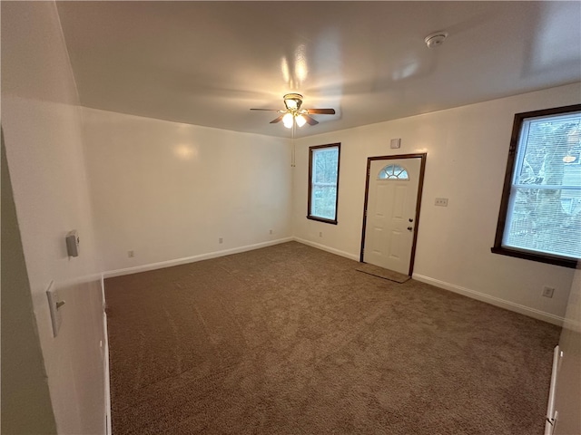 interior space featuring ceiling fan and dark carpet