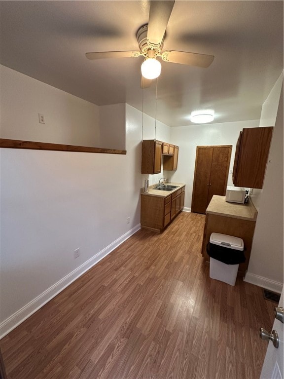 kitchen featuring dark hardwood / wood-style floors, ceiling fan, and sink