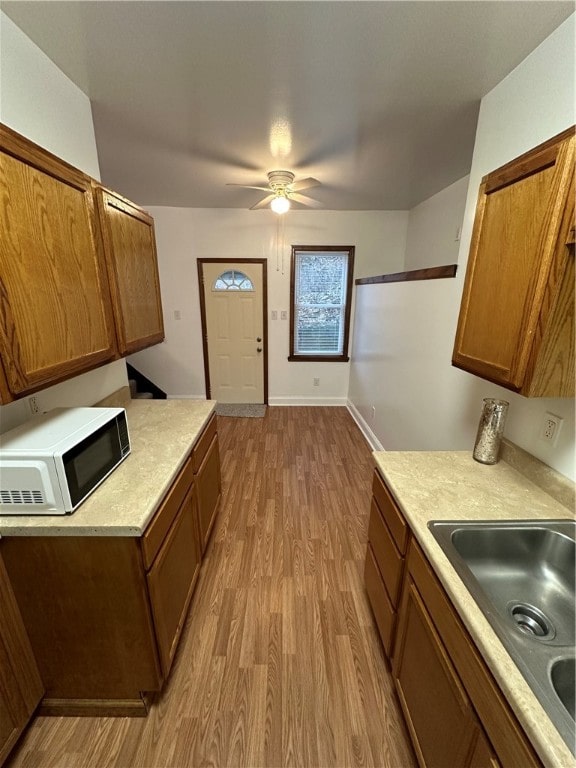 kitchen featuring ceiling fan, light hardwood / wood-style floors, and sink