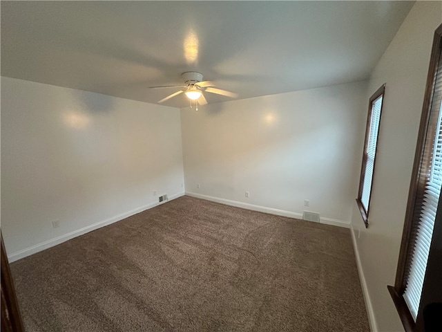 carpeted spare room featuring ceiling fan