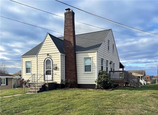 view of front of home with a deck and a front lawn