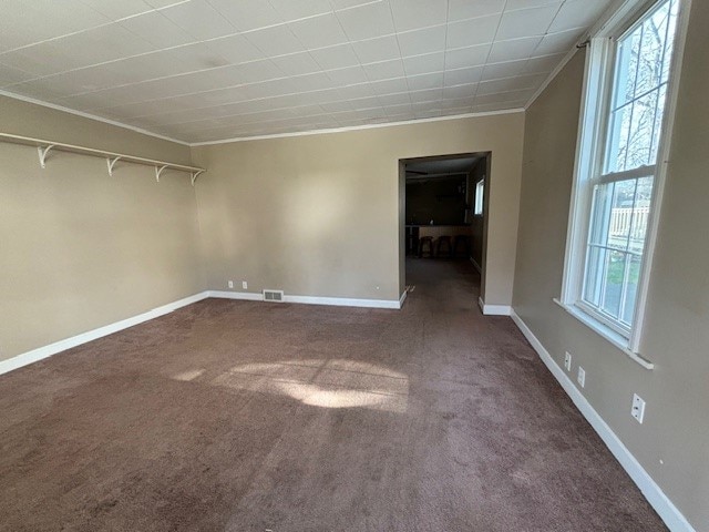 carpeted spare room featuring crown molding