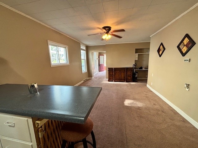 dining area featuring carpet flooring, ceiling fan, and crown molding