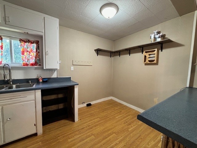 kitchen featuring light hardwood / wood-style floors, white cabinetry, and sink