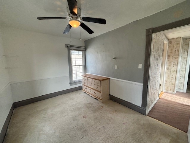 carpeted spare room featuring ceiling fan