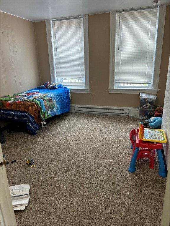 bedroom with carpet floors and a baseboard heating unit