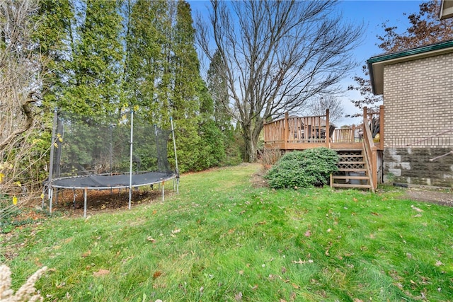 view of yard featuring a deck and a trampoline