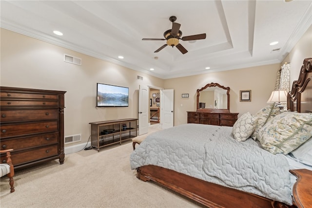 bedroom featuring ceiling fan, ornamental molding, light carpet, and a tray ceiling