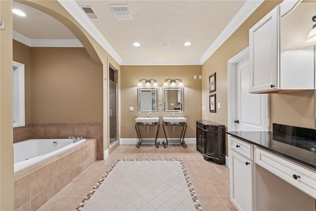 bathroom featuring tile patterned floors, ornamental molding, vanity, a textured ceiling, and independent shower and bath