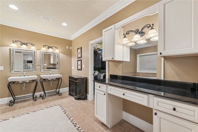 bathroom with a textured ceiling, tile patterned floors, and crown molding