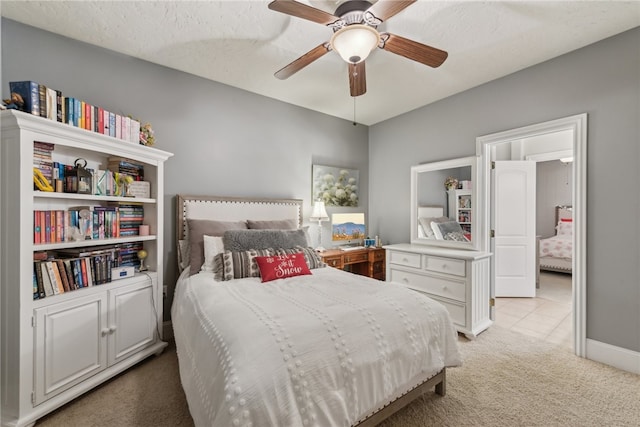 carpeted bedroom featuring a textured ceiling and ceiling fan