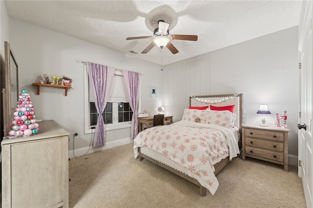 bedroom with a textured ceiling, light colored carpet, and ceiling fan