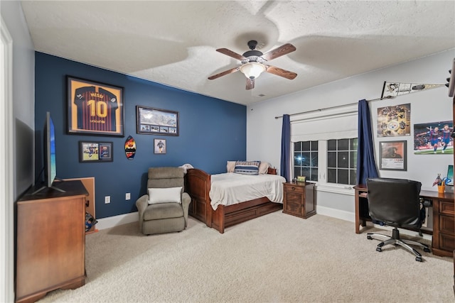 carpeted bedroom featuring ceiling fan and a textured ceiling