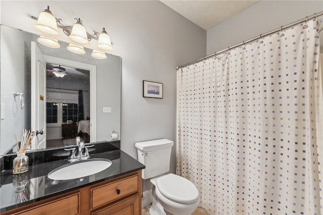 bathroom with a shower with curtain, vanity, toilet, and ceiling fan