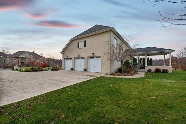 property exterior at dusk featuring a lawn and a garage