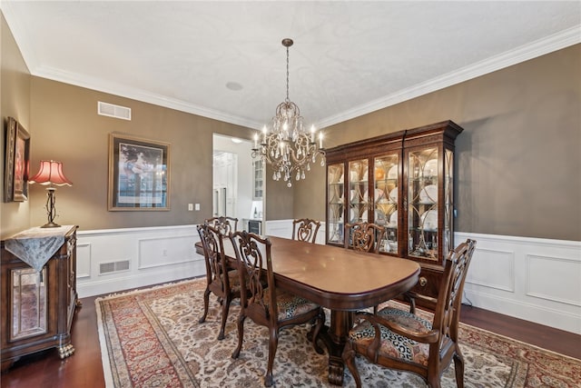 dining area featuring a chandelier, dark wood-type flooring, and crown molding