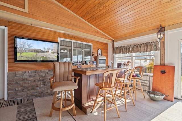 bar featuring wooden walls, light hardwood / wood-style floors, lofted ceiling, and wood ceiling