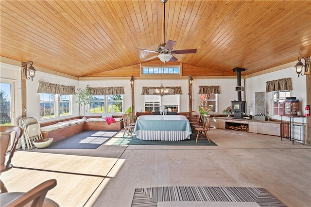 interior space featuring vaulted ceiling, an inviting chandelier, a wood stove, and wooden ceiling