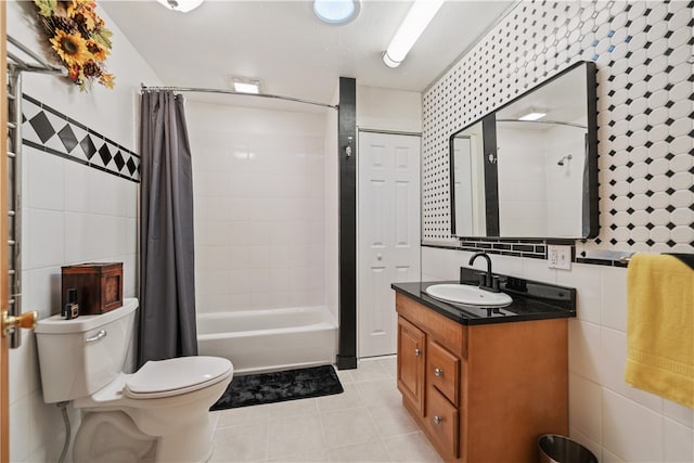 full bathroom featuring vanity, tile patterned flooring, toilet, shower / bath combo with shower curtain, and tile walls