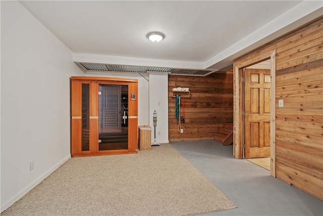 hall with carpet flooring and wooden walls