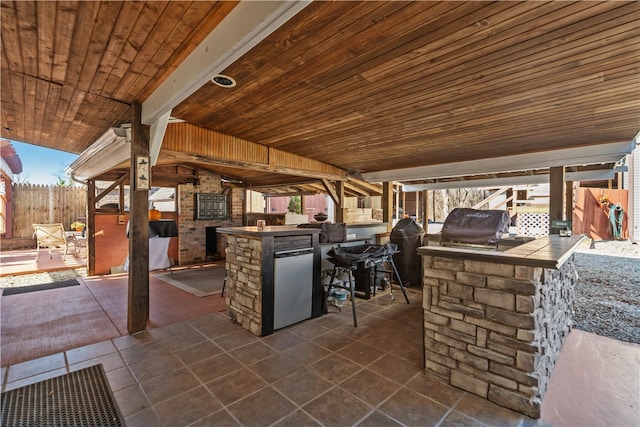 view of patio featuring an outdoor kitchen, an outdoor bar, and grilling area