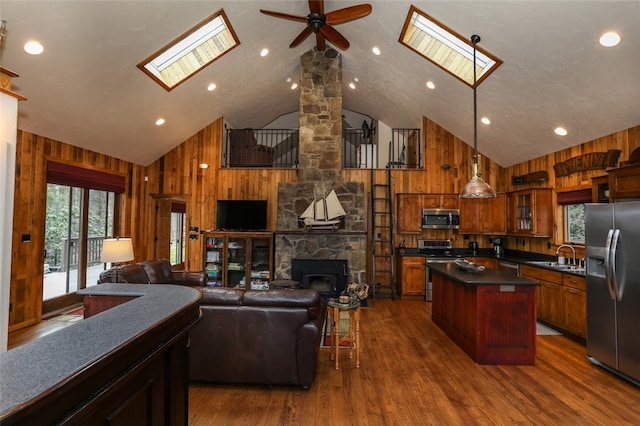 kitchen with wood walls, appliances with stainless steel finishes, and a skylight