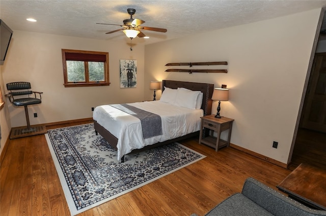 bedroom featuring a textured ceiling, dark hardwood / wood-style floors, and ceiling fan