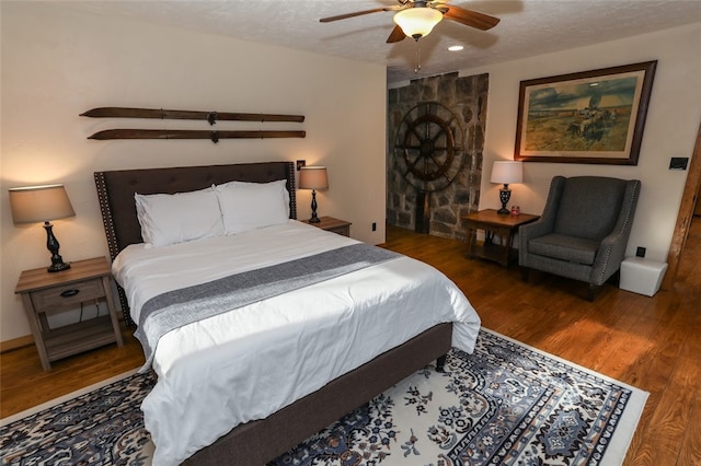 bedroom featuring a textured ceiling, ceiling fan, and dark wood-type flooring