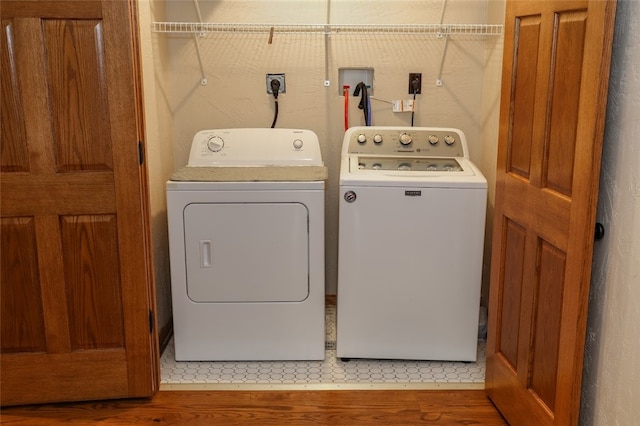 laundry room featuring washer and clothes dryer and hardwood / wood-style floors