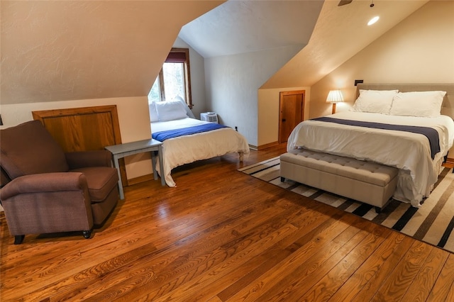 bedroom with light wood-type flooring and lofted ceiling