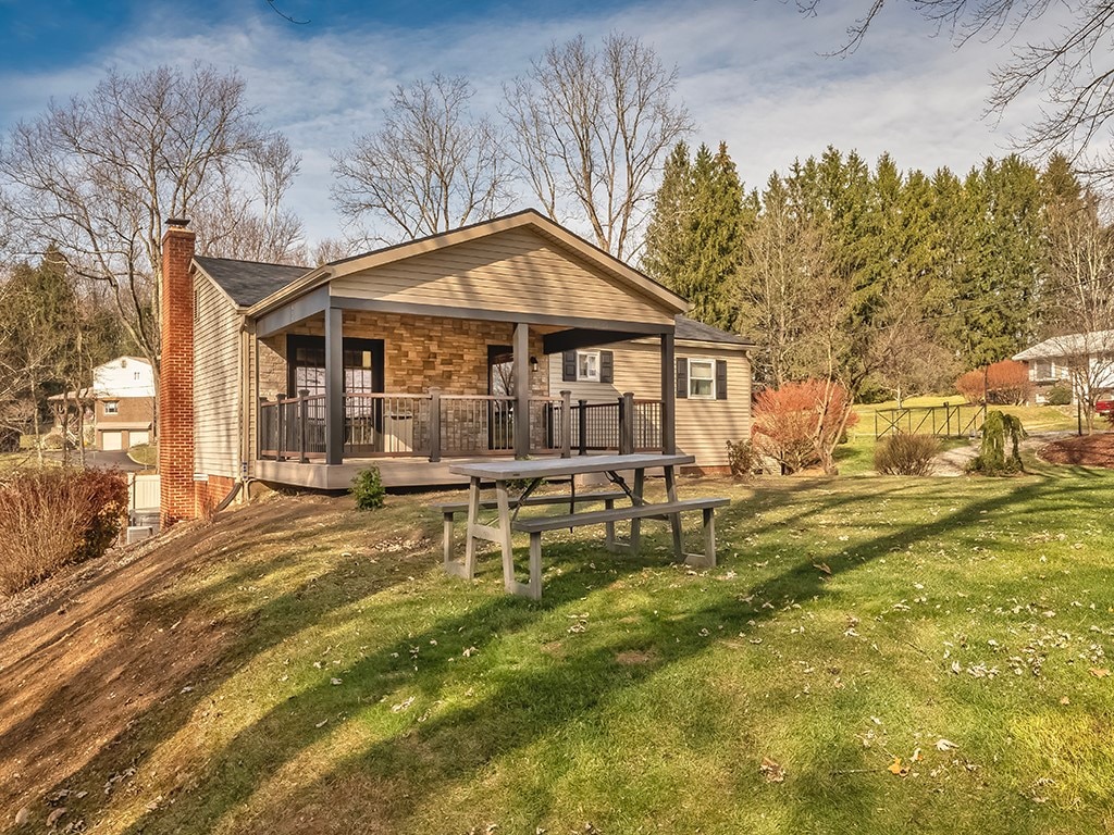 rear view of property with a deck and a lawn