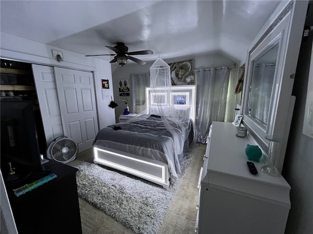 carpeted bedroom featuring ceiling fan, lofted ceiling, and a closet