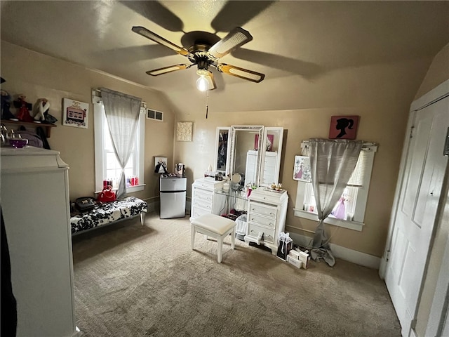 carpeted bedroom featuring vaulted ceiling, ceiling fan, and stainless steel refrigerator