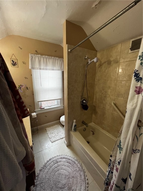 bathroom featuring tile patterned floors, toilet, and shower / tub combo with curtain