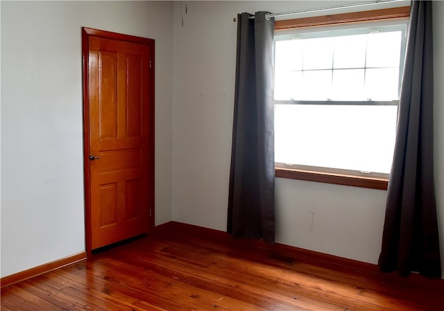 unfurnished room with wood-type flooring