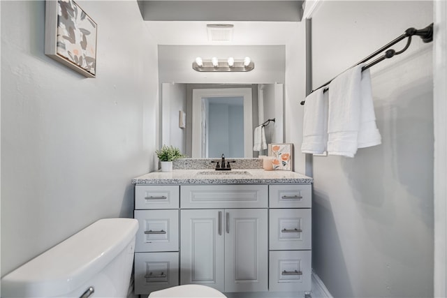 bathroom featuring vanity and toilet