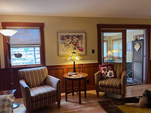 living area featuring wooden walls and light hardwood / wood-style floors