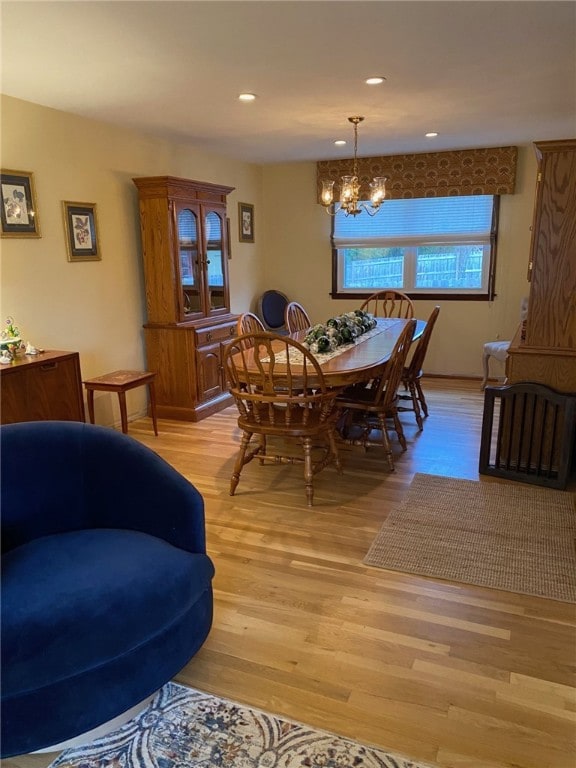 dining space featuring a notable chandelier and light wood-type flooring